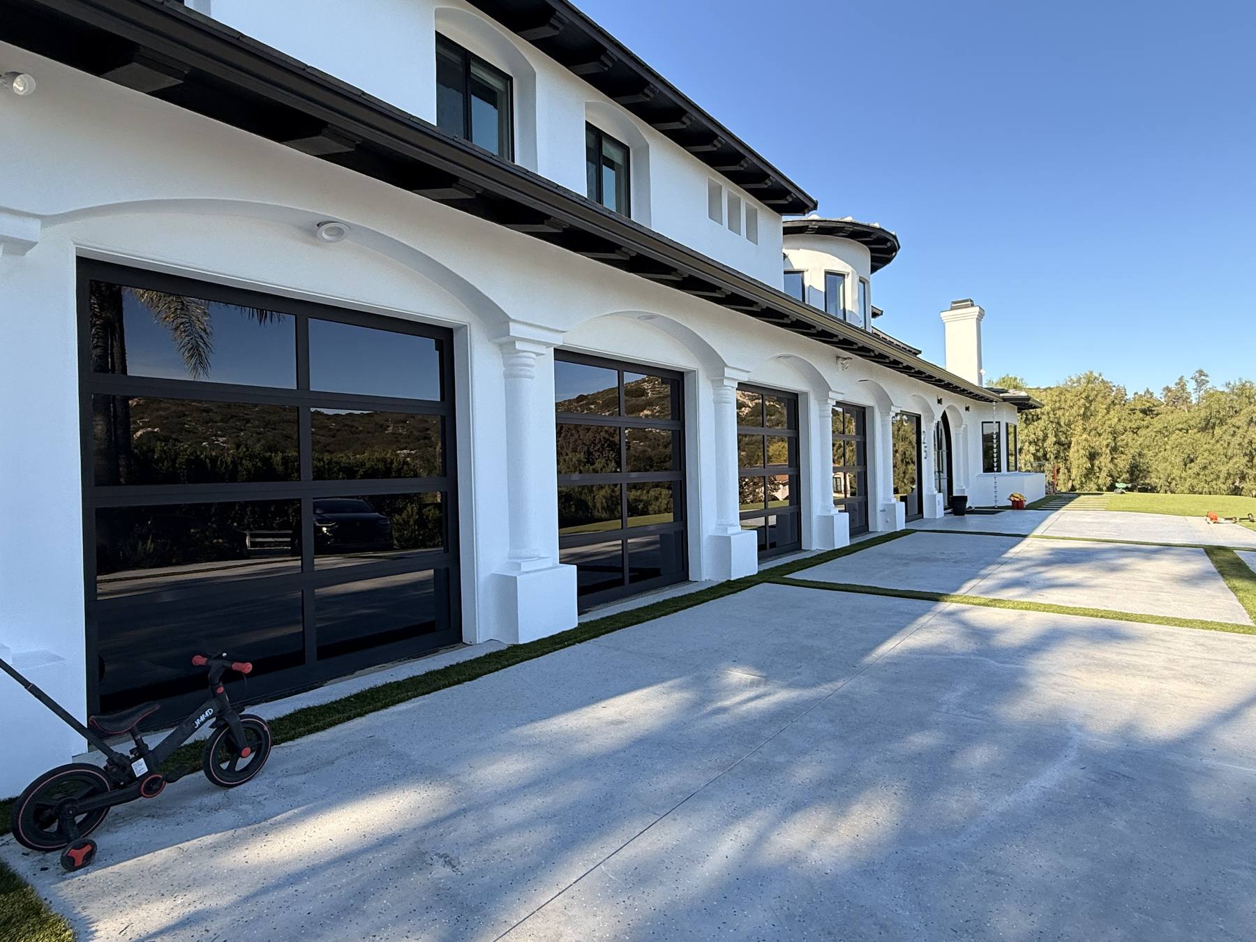 Estate with a row of full-view glass garage doors cleaned by Sudbud