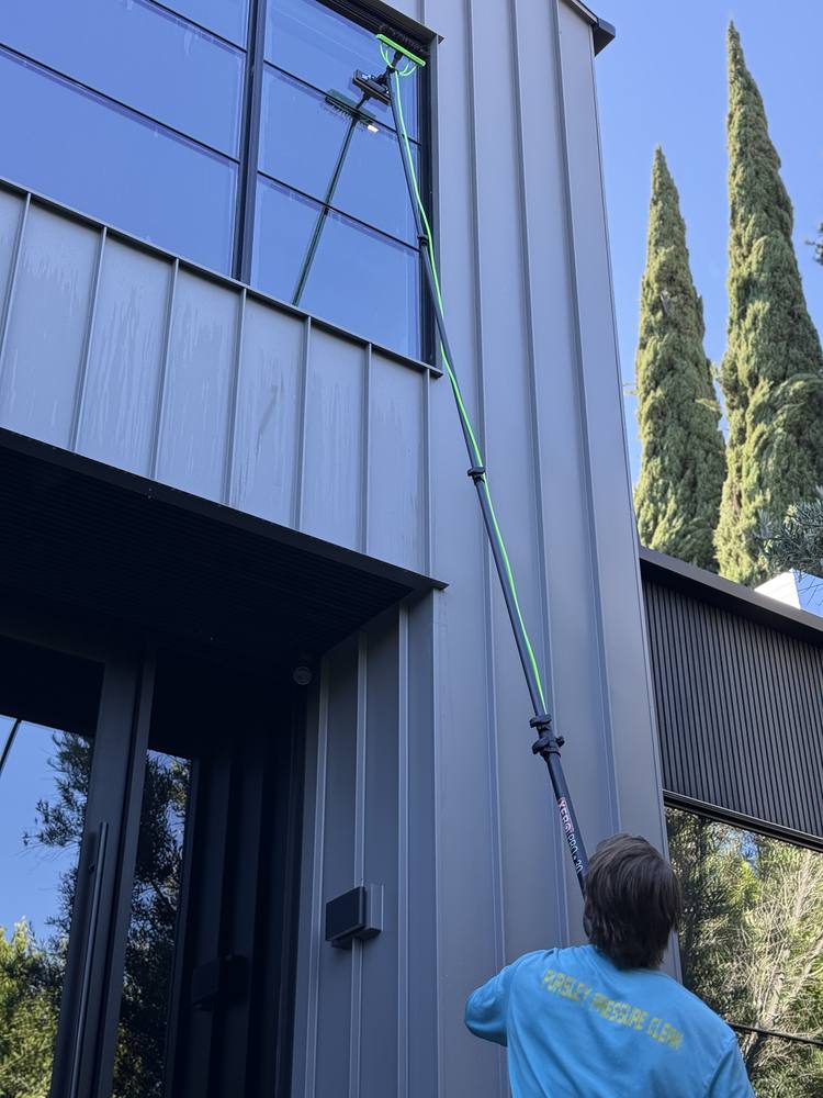 Cleaning a tall window wall above a front door